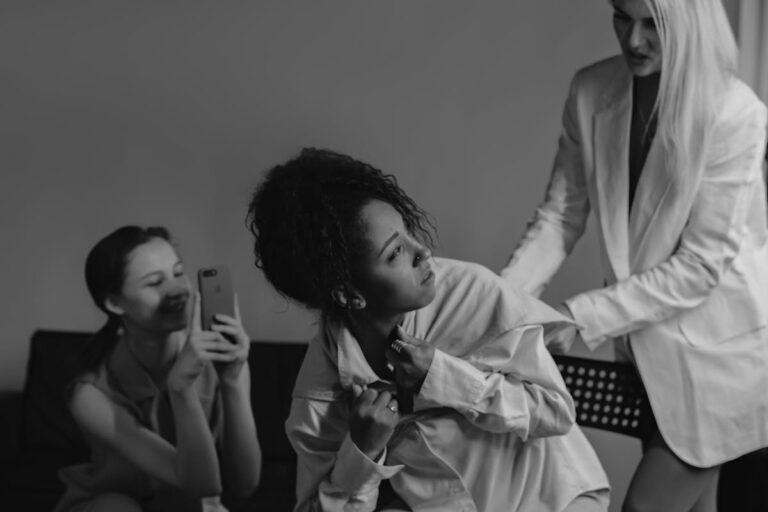 Grayscale Photo of a Woman in White Blazer Bullying a Woman in White Dress Shirt