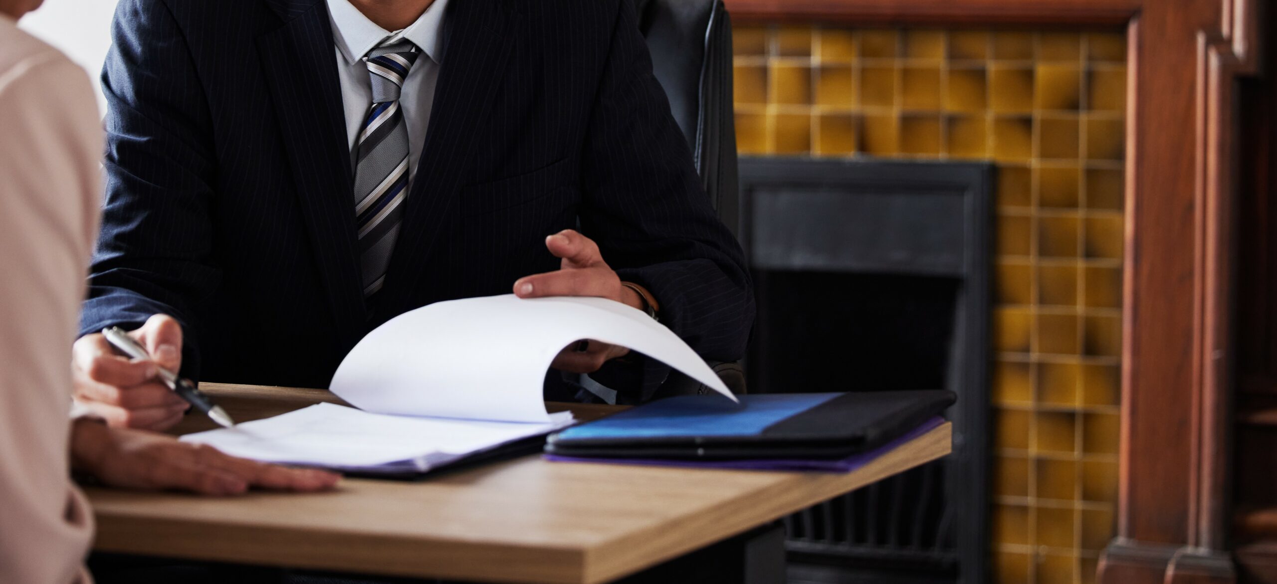 Contract, signing and lawyer consulting a client in his office with legal paperwork or agreement. Signature, approval and businessman in discussion with a woman with a document to sign in workplace.