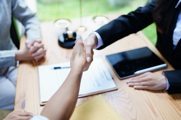 Law, consultation, agreement, contract, lawyer or attorney shakes hands to agree on the client's offer to be hired to fight the parties in court