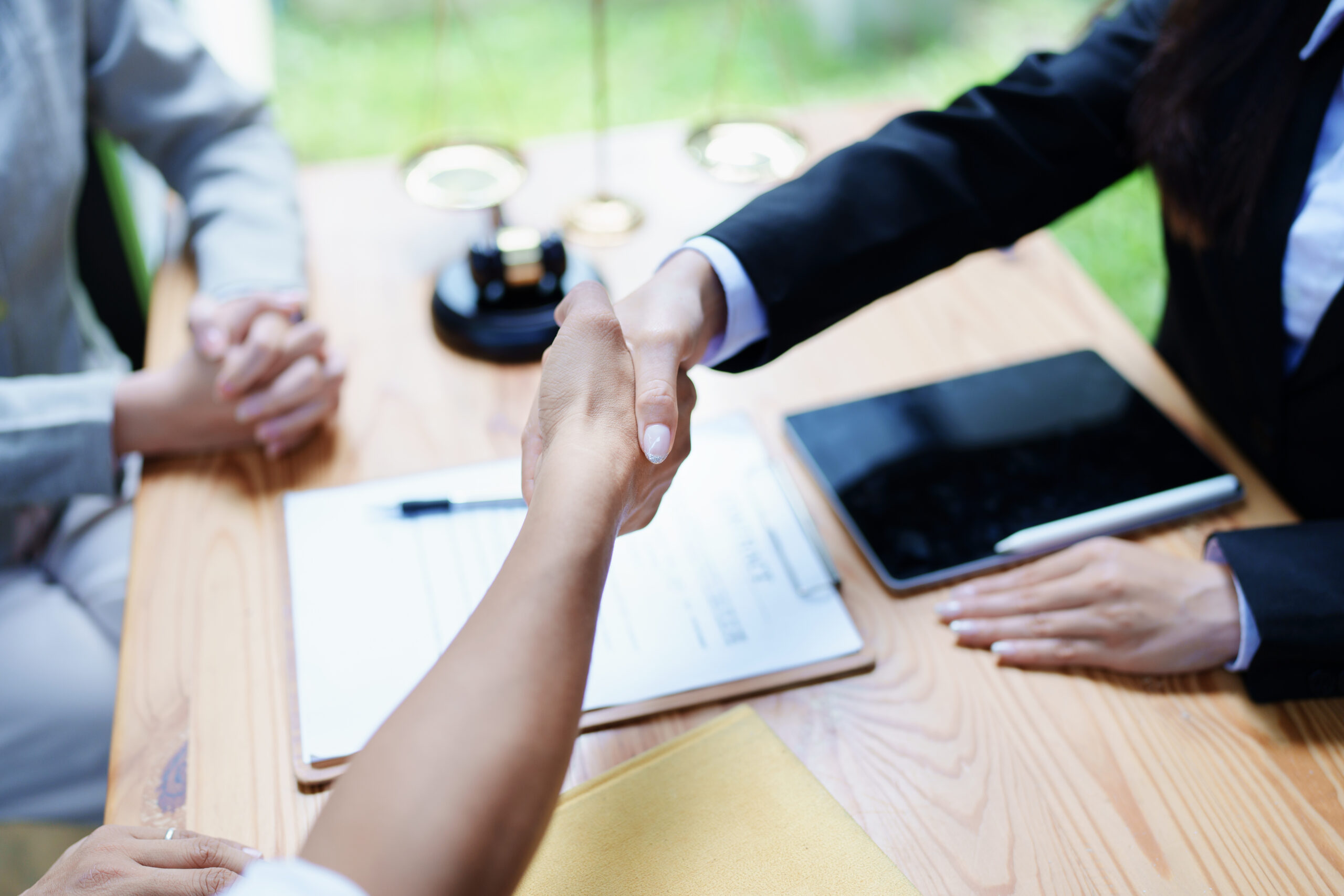 Law, consultation, agreement, contract, lawyer or attorney shakes hands to agree on the client's offer to be hired to fight the parties in court